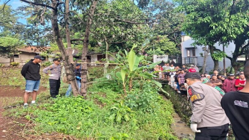 Petugas kepolisian melakukan olah TKP penemuan mayat pria di sebuah selokan Desa Sukalilah, Cibatu, Garut